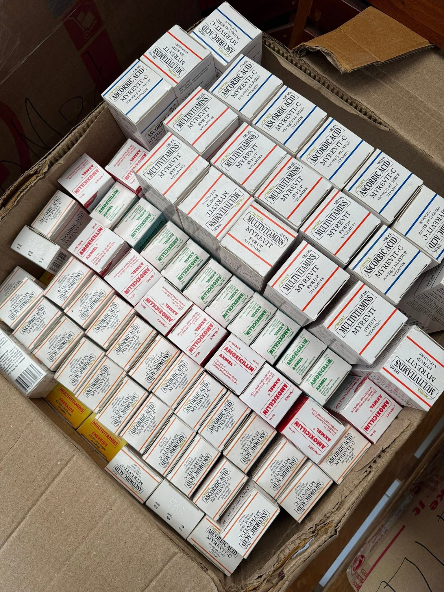 An open cardboard box contains neatly arranged medicine cartons.